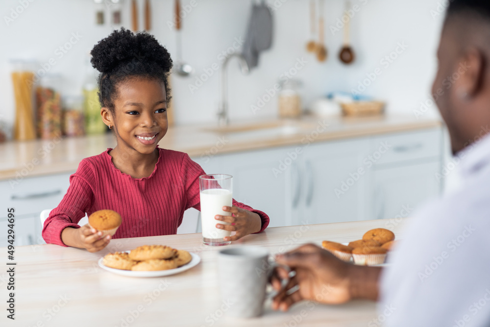 Cute african american little girl drinking milk, eating cookies Cute african american little girl drinking milk, eating cookies