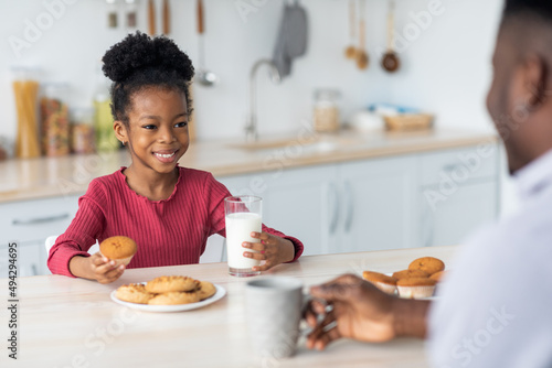 Cute african american little girl drinking milk  eating cookies