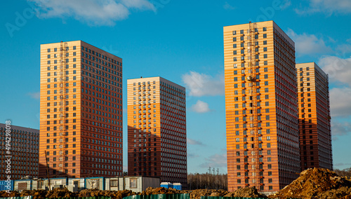 View of new high-rise orange-brown houses with balconies and air conditioning platforms on a clear sunny day  construction business investment.