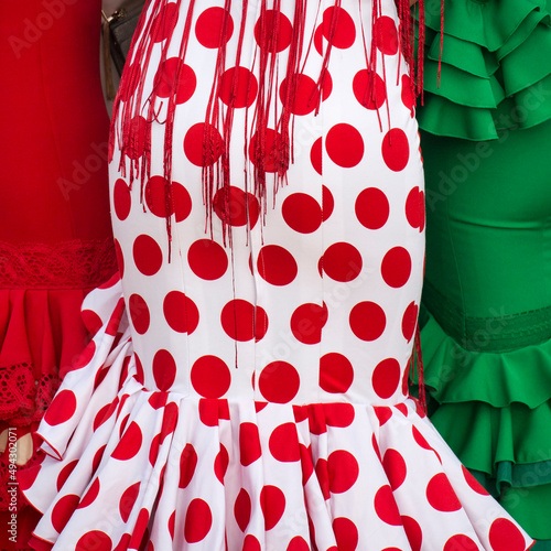 Pencil skirts of three Sevillian costumes in the Feria de Abril  photo