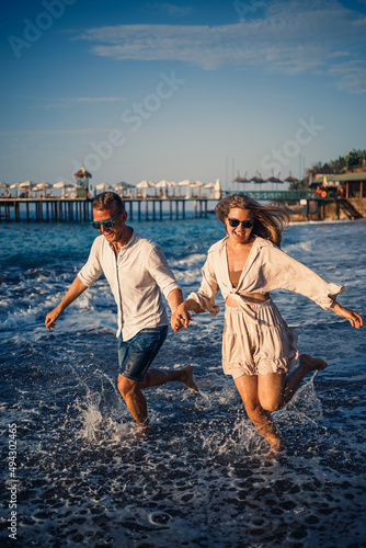 romantic young couple in love together on the sand walks along the beach of the Mediterranean sea. Summer vacation in a warm country. © Дмитрий Ткачук