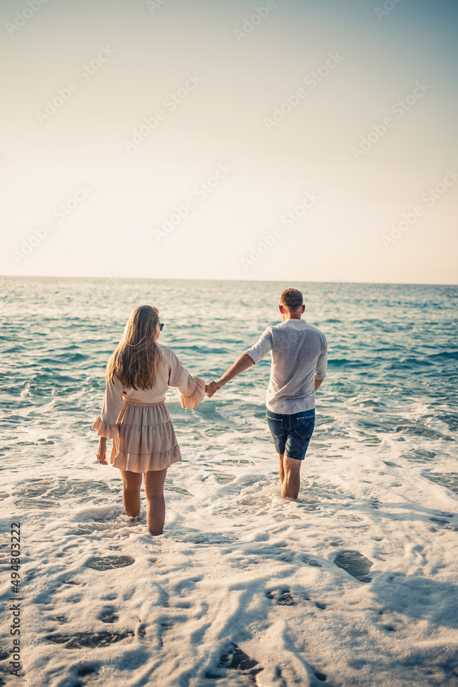 Happy couple by the sea. Honeymoon lovers. Man and woman on the island. Beautiful couple having fun on the seashore. Happy couple on vacation. Man and woman by the sea.