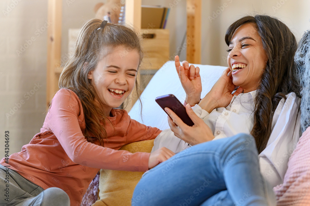 Mother and daughter having fun together at home. Cheerful people. Spending quality time with a child. Parenting concept. Mother and daughter having fun together at home. Cheerful people. Spending quality time with a child. Parenting concept.