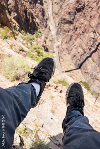 Vertical shot of feet dangerously hanging off a tall ledge