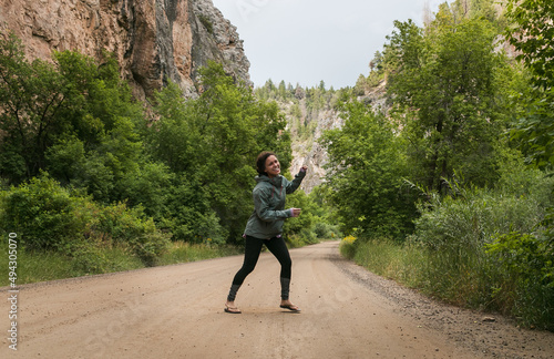 Happy sporty girl dancing on a dirt road