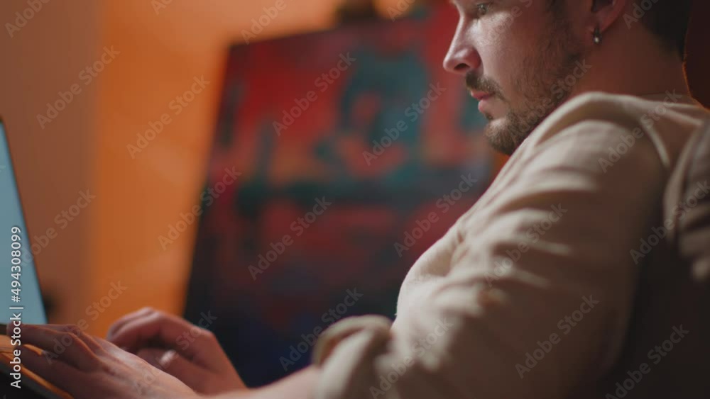 Stylish creative designer artist working on laptop in workshop, create project. Mock-up blank screen. ProRes codec Stylish creative designer artist working on laptop in workshop, create project. Mock-up blank screen. ProRes codec