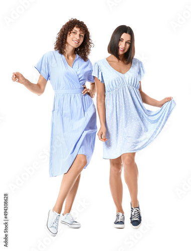 Young sisters posing on whi...