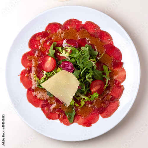 veal carpaccio on a white plate top view