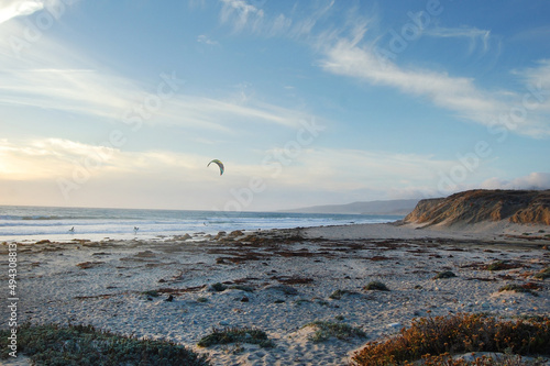 A kiteboarder and two surfers enjoying their time at Jalama Beach, in Santa Barbara County, California.