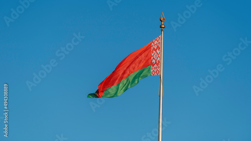 State flags of the Republic of Belarus are waving in the wind on blue sky background. Space for text.