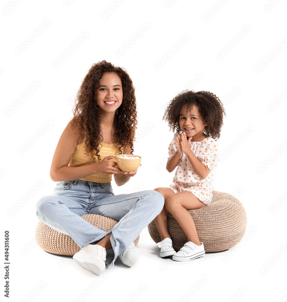 Little African-American girl and her mother with cup of sweet cocoa on white background Little African-American girl and her mother with cup of sweet cocoa on white background