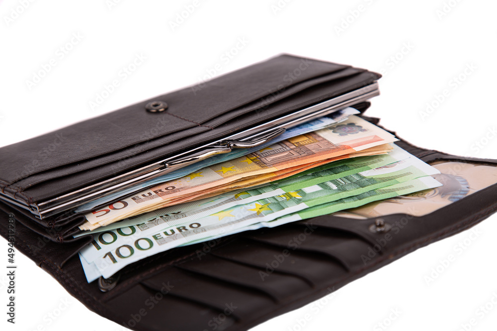 An open wallet full of money in denominations of 50 and 100 euros isolated on a white background close-up An open wallet full of money in denominations of 50 and 100 euros isolated on a white background close-up
