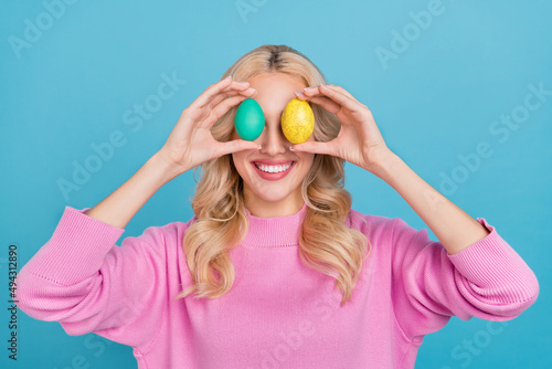 Photo of nice young wavy blond lady hold eggs wear pink pullover isolated on blue color background © deagreez