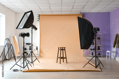 Lighting equipment, stool and beige cyclorama in modern photo studio photo