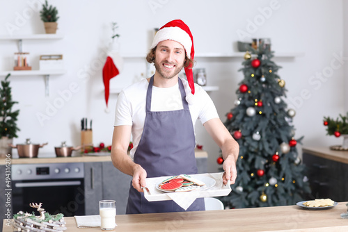 Young man in Santa hat hold...
