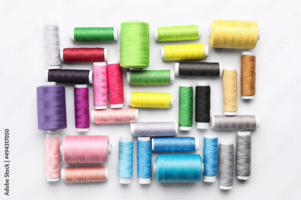Multicolored sewing thread spools on white background Multicolored sewing thread spools on white background