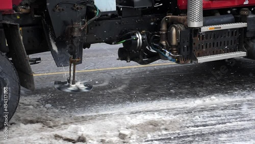 Truck mounted salter applying salt to snowy street. Slow motion. Toronto, Ontario, Canada.