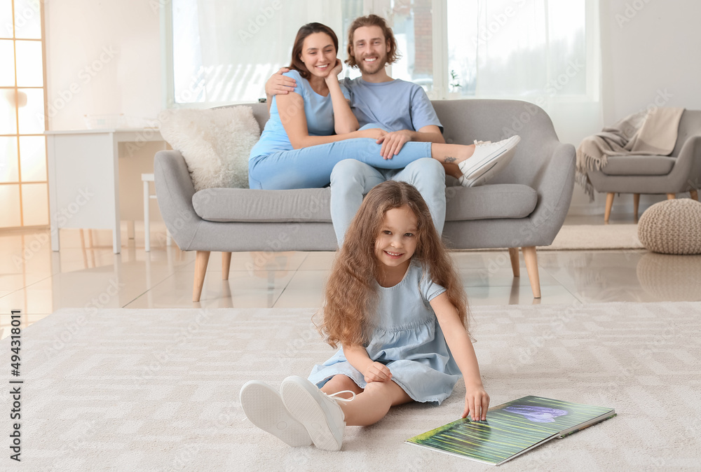 Little girl reading book on carpet at home Little girl reading book on carpet at home