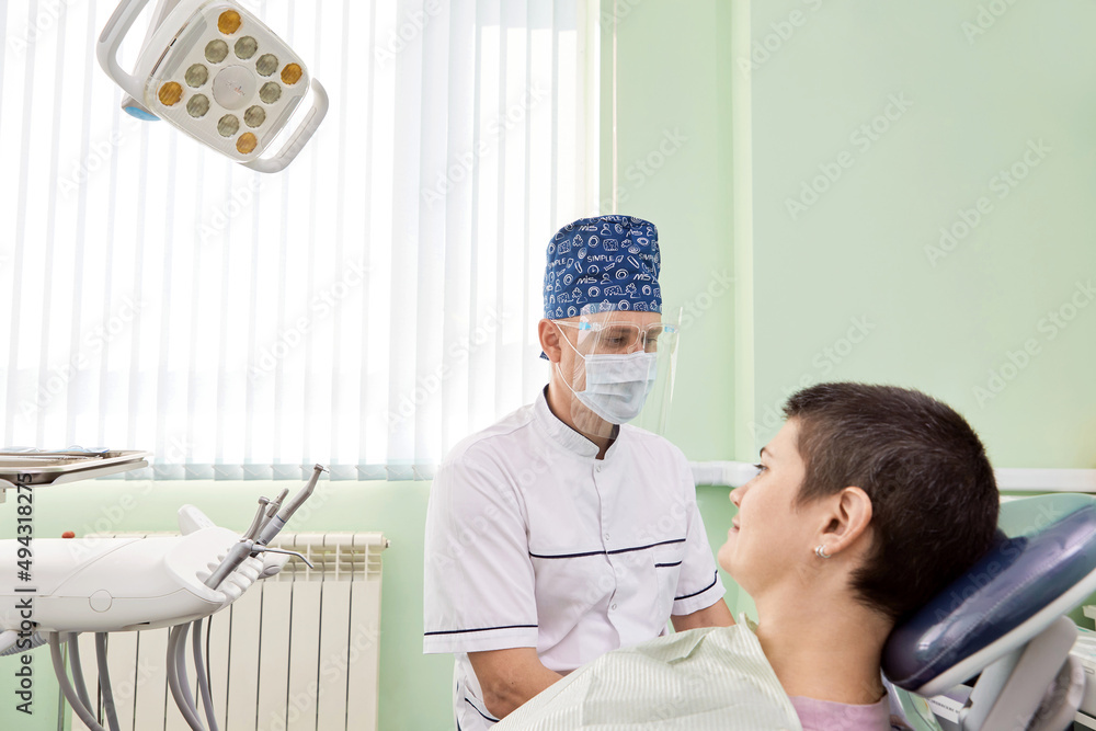 Woman and dentist in the dental office. Patient sitting in a dental armchair. Woman and dentist in the dental office. Patient sitting in a dental armchair.