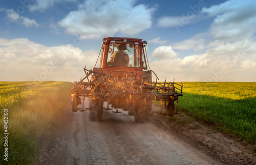 tractor on the road after working on the farm on sunset. Silhouette of old tr...