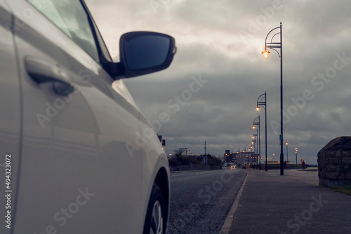Car parked and illuminated city lights. Salthill promenade, Galway city. Ireland. Dusk time. Tourism in Ireland.