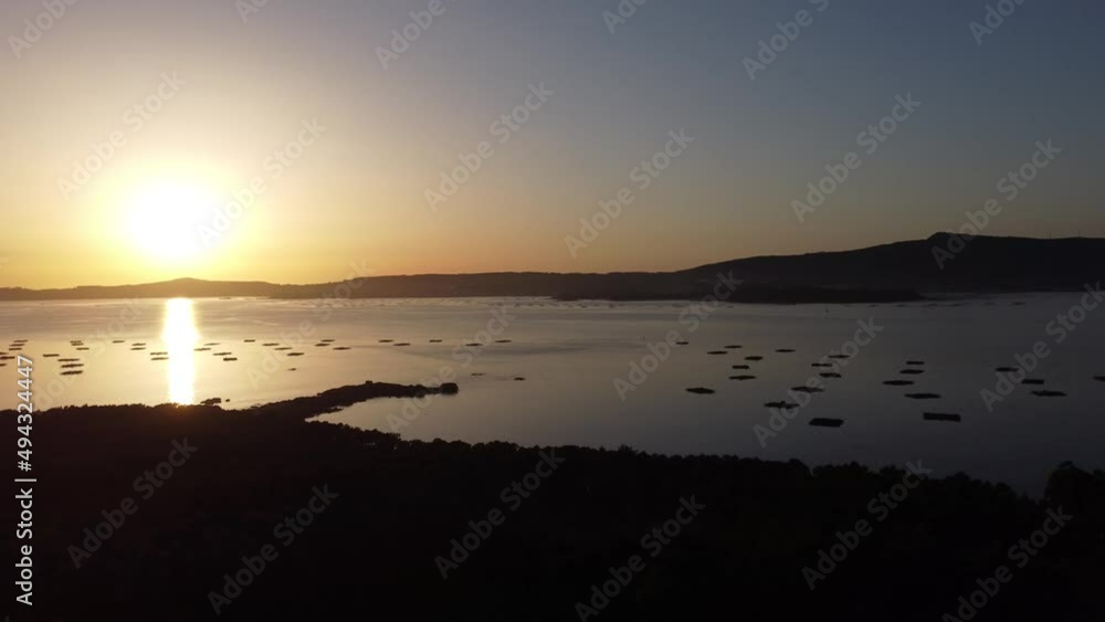 An aerial view of a forest in back light with three antenas on the middle of that same forest, there is a sea behind of this forest An aerial view of a forest in back light with three antenas on the middle of that same forest, there is a sea behind of this forest
