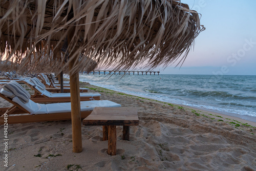 Sunset view of reed parasols at Shkorpilovtsi beach in Bulgaria. photo