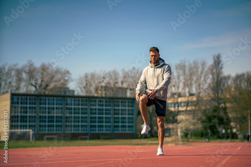 A muscular athlete stretches before a sports training session at a sports stadium © DusanJelicic