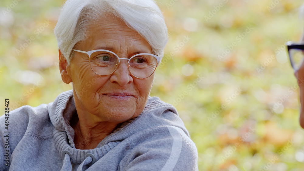 Portrait of senior Caucasian woman grey hair and glasses looking at her husband and smiling in the park senior people support concept selective focus copy space . High quality photo Portrait of senior Caucasian woman grey hair and glasses looking at her husband and smiling in the park senior people support concept selective focus copy space . High quality photo