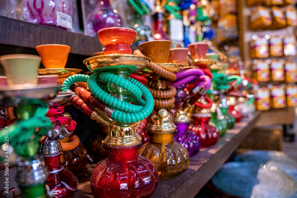 Naklejka premium Various colorful hookahs display on souvenirs stand at market for sale