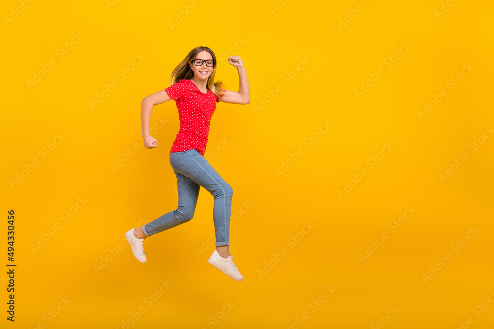 Full size profile side photo of young girl hurry speed runner jumper motion isolated over yellow color background