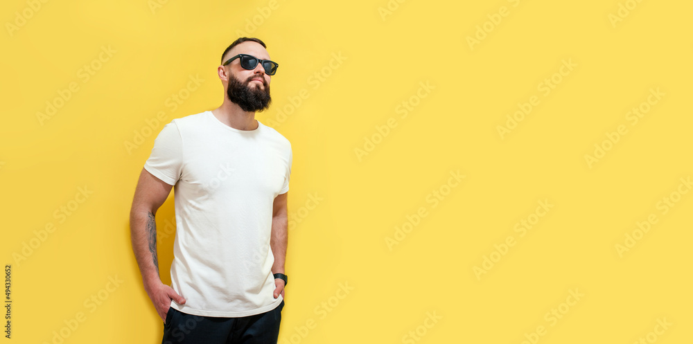 Young bearded hipster guy wearing white blank t-shirt. Studio shot on yellow background. Mock-up for print. T-shirt template. Young bearded hipster guy wearing white blank t-shirt. Studio shot on yellow background. Mock-up for print. T-shirt template.