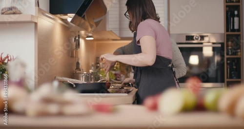 Senior and young woman cooking family dinner together at home kitchen
