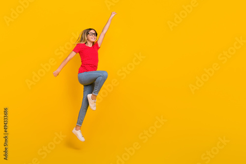 Full body profile side photo of youth active girl jump power hero look empty space isolated over yellow color background