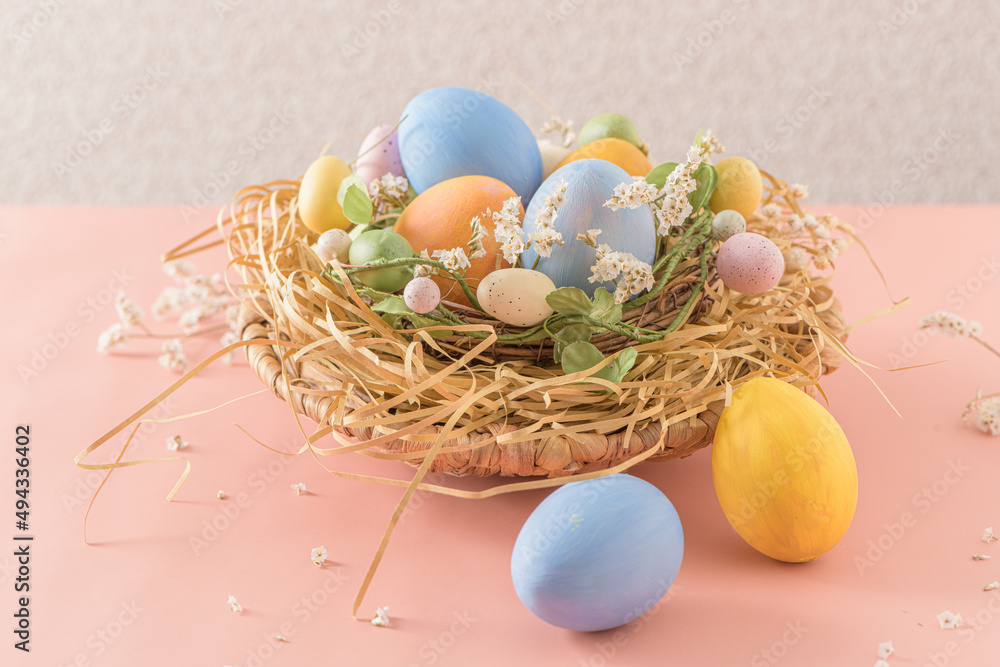 Easter eggs in nest on pink background.