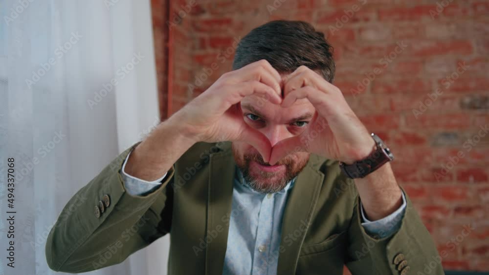 European lad making a heart with his fingers and looking through the gap. High quality 4k footage European lad making a heart with his fingers and looking through the gap. High quality 4k footage