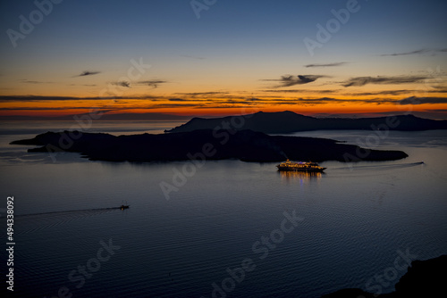 Aerial shot of a cruise ship at anchor in the calder Santorini on a red Sunset , Greece photo