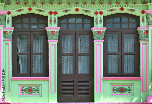 Photography Lime green Straits Chinese Peranakan shophouse with arched windows, brown louver