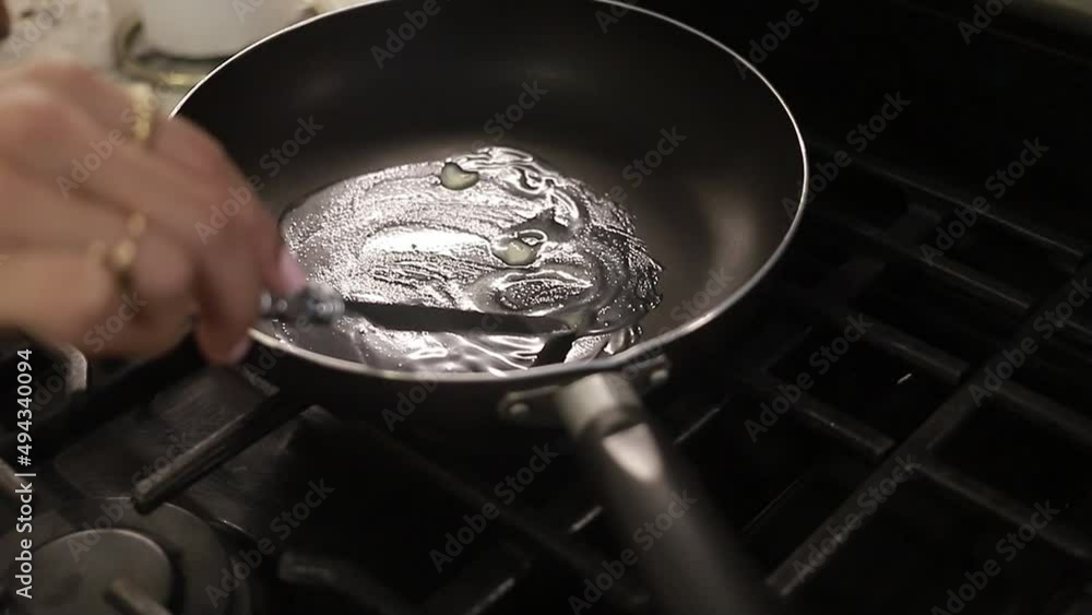 chica joven preparando la sartén con mantequilla para preparar el desayuno, la comida en casa.