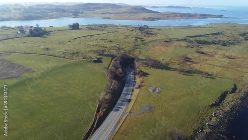 Subsea byfjord tunnel in Stavanger Norway - Aerial approaching and decending towards entrance in sunny weather and surrounded by green grasslands photo