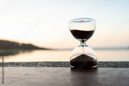 Hand holding the hour glass with sea background. time to relax and summer concepts. © sommart
