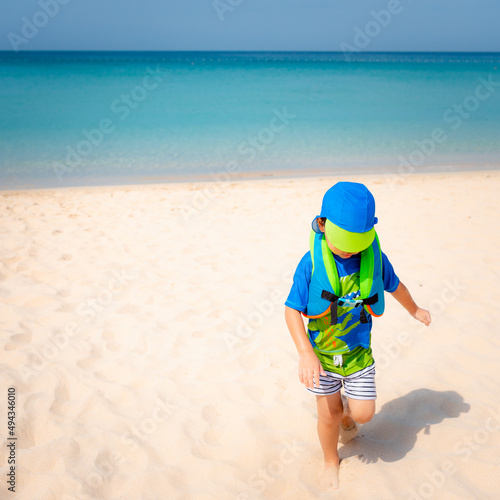 Fototapeta Naklejka Na Ścianę i Meble -  Happy little boy playing on the sand with sea, summer beach.