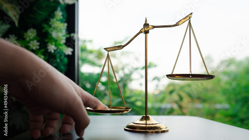 Tip the scales of justice concept as a the hand of a person illegally influencing the legal system for an unfair advantage. photo