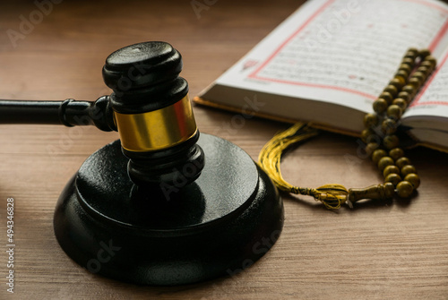 Sharia or Islamic law concept with gavel ,Quran and rosary beads on wooden background. photo