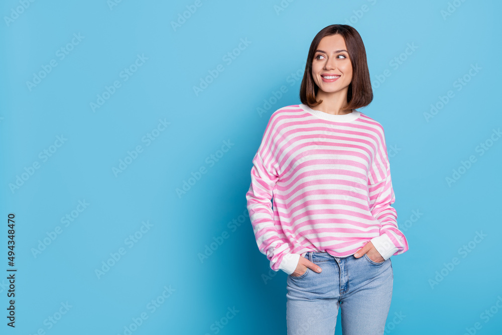 Photo of cute young lady look promo wear striped shirt jeans isolated on blue color background Photo of cute young lady look promo wear striped shirt jeans isolated on blue color background