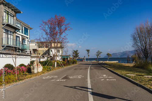 View of a bike and walking path next to some residential apartments in the daytime. photo