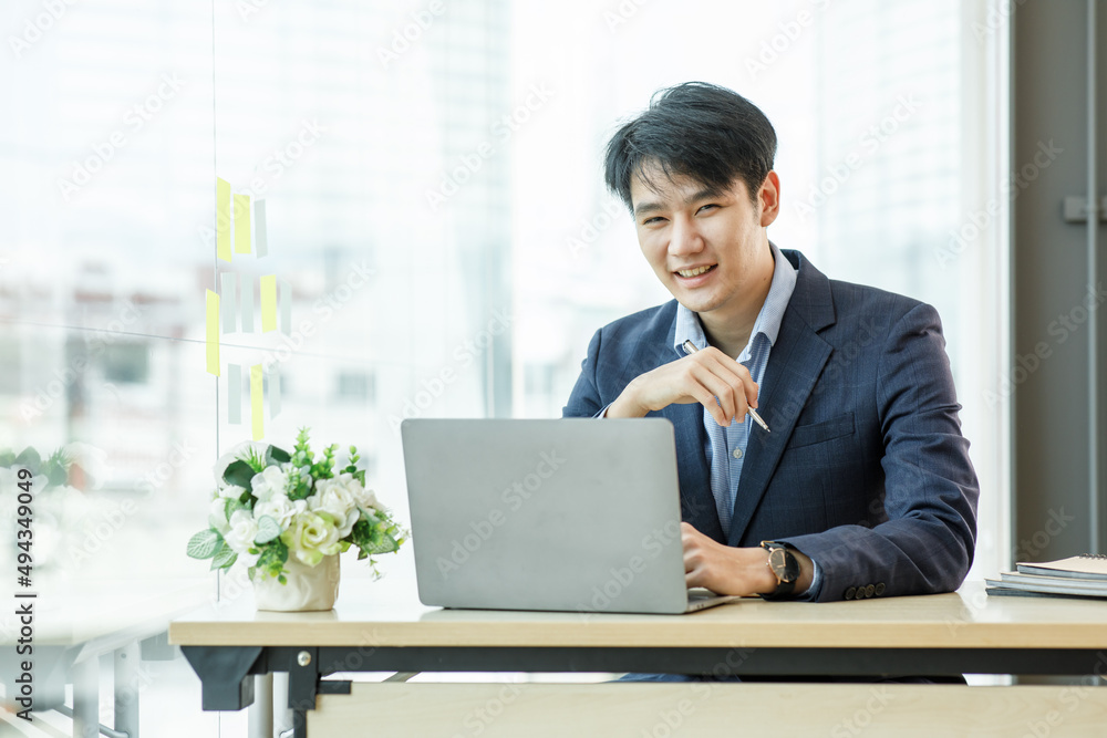 Celebrating success. Young asian business man working with laptop, tablet and papers on desk at office. He feeling good and happy. Celebrating success. Young asian business man working with laptop, tablet and papers on desk at office. He feeling good and happy.