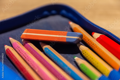 Selective focus shot of a school folder with colorful pencils and an eraser photo