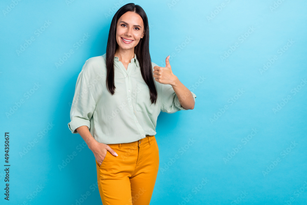 Photo of young cheerful girl show thumb-up approve promo good ads ideal isolated over blue color background Photo of young cheerful girl show thumb-up approve promo good ads ideal isolated over blue color background