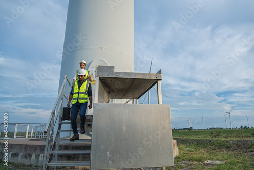 Service engineers walk on stair against turbines on wind turbine farm. renewable ennergy ,sustainable concept. © VIEWFOTO STUDIO